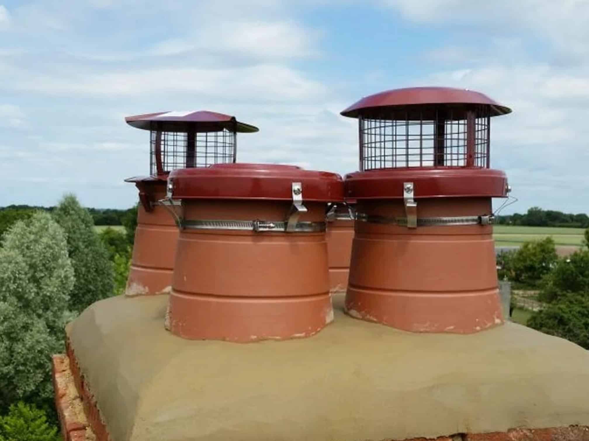 file (10) Traditional chimney pots with protective caps on a rooftop in Stafford.